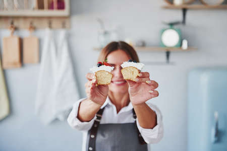 Woman stands indoors in the kitchen with homemade pie.の写真素材