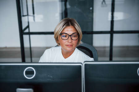 Female stockbroker in formal clothes works in the office with financial market.の写真素材