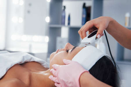 Using special device. Close up view of woman that lying down in spa salon and have face cleaning procedure.の写真素材