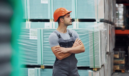 Portrait of young worker in unifrorm that is in warehouse.