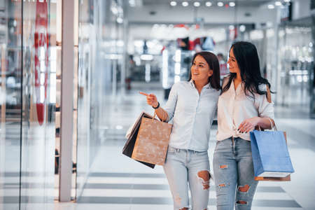 Two young women have a shopping day together in the supermarket.の写真素材