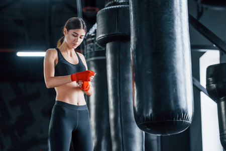 Young woman in sportive wear is in the gym having exercise day. Conception of boxing.