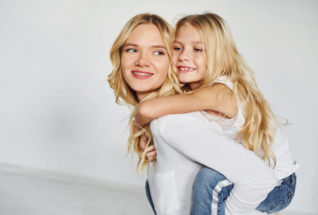 Mother with her daughter have fun together in the studio with white background.の写真素材