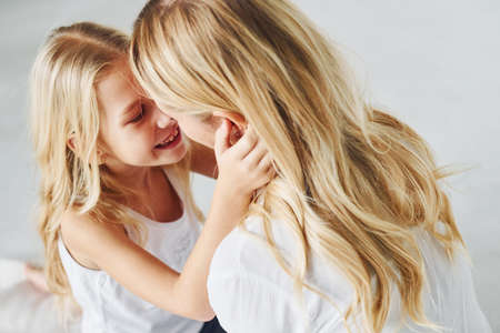 Mother with her daughter together in the studio with white background.の写真素材