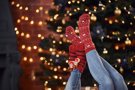 Mother with her little daughter lying down on floor indoors in festive clothes at christmas...
