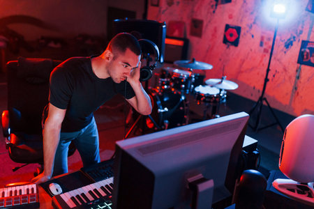 Professional sound engineer working and mixing music indoors in the studio.