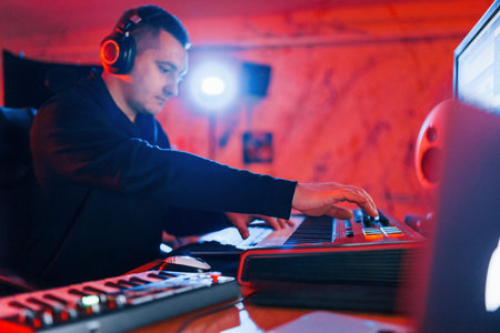 Young soung engineer working and mixing music indoors in the studio.