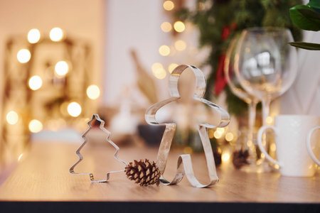 Glasses and x-mas decorations in the room. Bright garlands and lights.