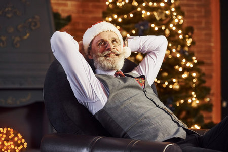 Portrait of stylish senior with grey hair and beard in jacket and white shirt is in decorated...
