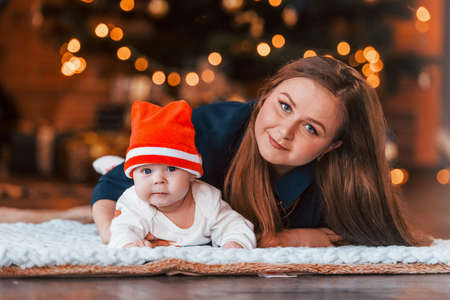 Mother with her child together in christmas decorated room.の写真素材