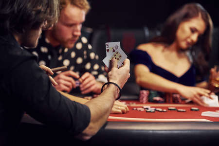 Group of elegant young people that playing poker in casino together.の写真素材
