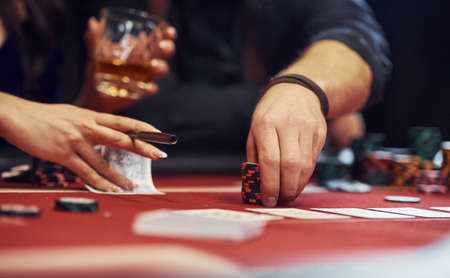 Close up view of elegant young peoples hands that playing poker in casino.の写真素材