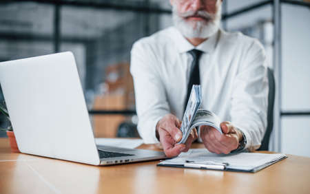 Close up view of businessman that holds money in hands in the office.の写真素材