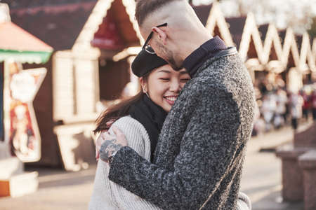 Lovely multiracial couple have a walk in the city and embracing each other.の写真素材