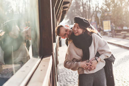 Playful and lovely multiracial couple together outdoors in the city. Asian girl with her caucasian boyfriend.の写真素材