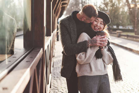 Playful and lovely multiracial couple together outdoors in the city. Asian girl with her caucasian boyfriend.の写真素材