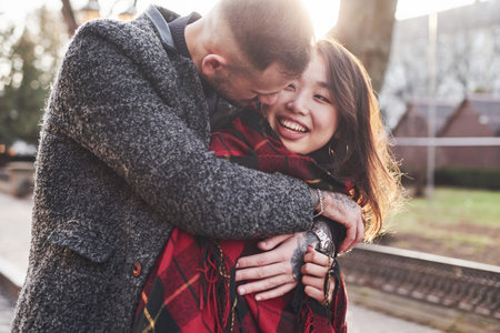 Beautiful sunlight. Happy multiracial couple together outdoors in the city.