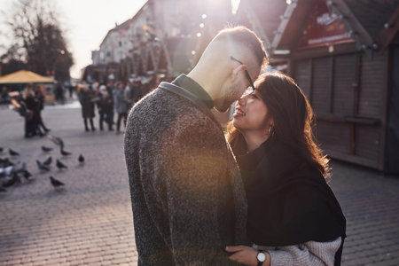 Beautiful sunlight. Happy multiracial couple together outdoors in the city.