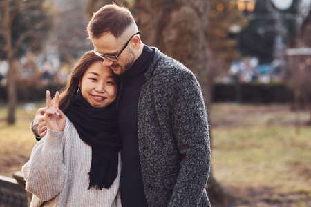 Happy multiracial couple together outdoors in the city. Asian girl with her caucasian boyfriend.の写真素材