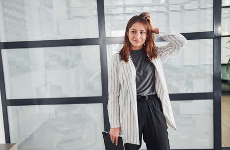 Portrait of young woman in white formal clothes that standing indoors.の写真素材