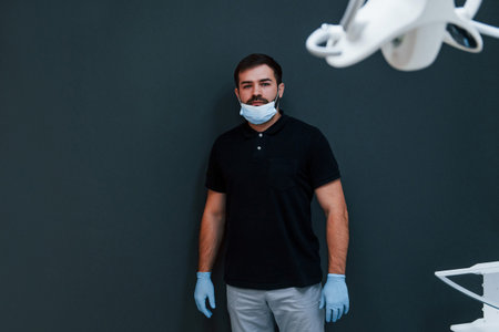 Portrait of dentist in gloves that standing indoors in the clinic.の写真素材