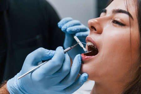 Close up view of young adult woman that have a visit in the dentist clinic. Conception of stomatology.の写真素材