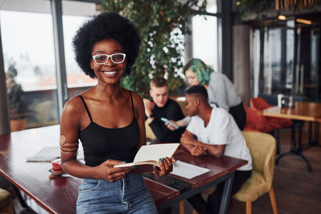 Black woman standing in front of group of multi ethnic people with alternative girl with green hair...