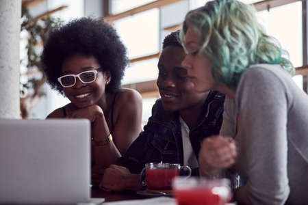 Group of multiracial people that sitting together by table and using laptop.の写真素材