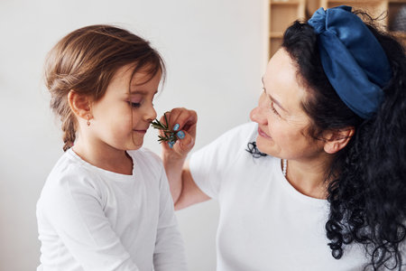 Senior woman have fun with her granddaughter on the kitchen.