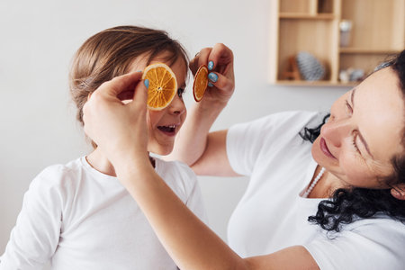 Senior woman have fun with her granddaughter on the kitchen.の写真素材