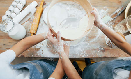Top view of two little girls in blue chef uniform that preparing food on the kitchen.の写真素材