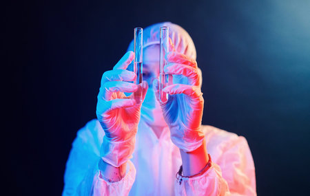 Nurse in mask and white uniform standing in neon lighted room and holding tubes with samples.