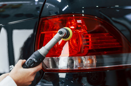 Woman with equipment cleaning modern automobile. Conception of service.