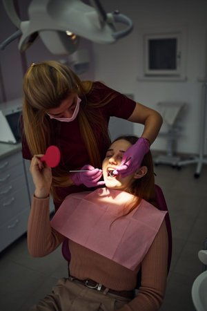 Little girl visiting dentist in clinic. Conception of stomatology.