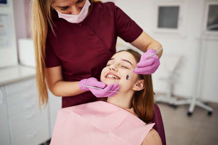 Little girl visiting dentist in clinic. Conception of stomatology.の写真素材