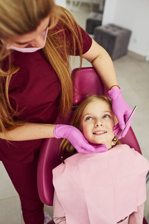 Little girl visiting dentist in clinic. Conception of stomatology.