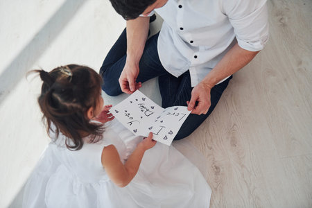 Happy fathers day. Daughter makes surprise for dad by giving postcard with heart.