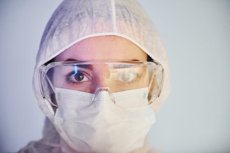 Portrait of female doctor scientist in lab coat, defensive eyewear and mask.の写真素材