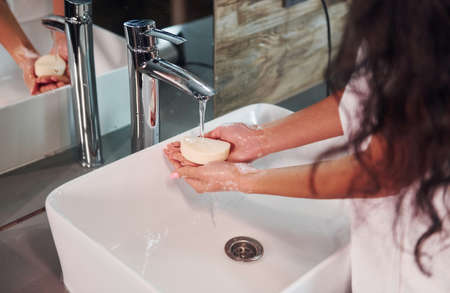 Close up view of woman that standing in bathroom and washing hands.の写真素材