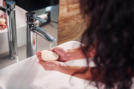 Close up view of woman that standing in bathroom and washing hands.の写真素材
