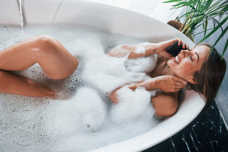 Top view. Beautiful young woman have free time at home in the bathの写真素材