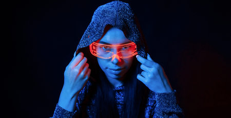 Portrait of young girl that is in eyeglasses in blue neon lighting