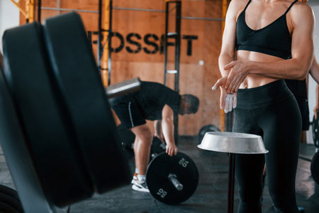 Group of young sportive people have crossfit day indoors in gym