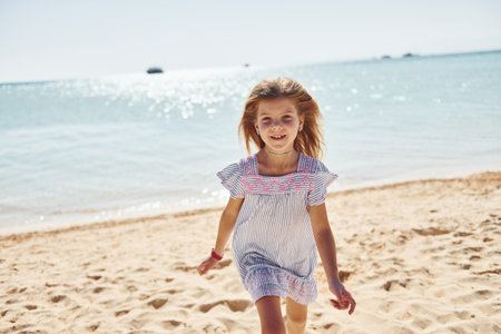 Little girl have vacation on the sea at sunny daytime. Conception of travelの写真素材