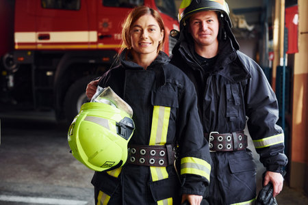 Male and female firefighters in protective uniform standing togetherの写真素材