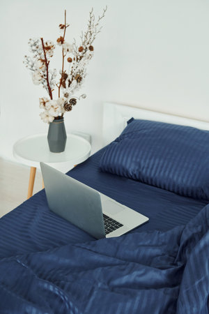 Laptop is on the bed. Interior and design of beautiful modern bedroom at daytimeの写真素材