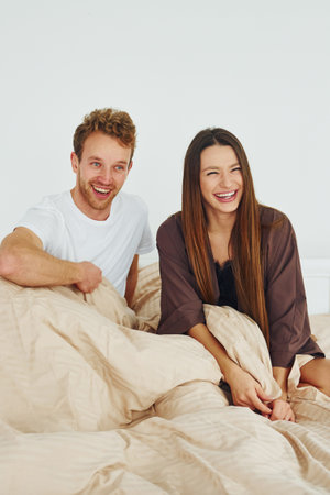 Happy couple together. Interior and design of beautiful modern bedroom at daytimeの写真素材