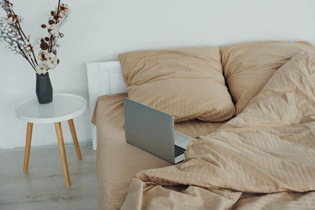 Laptop is on the bed. Interior and design of beautiful modern bedroom at daytimeの写真素材