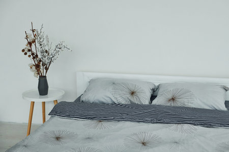 Grey bed. Interior and design of beautiful modern bedroom at daytime