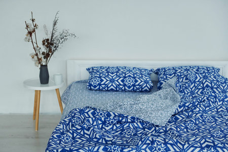 Blue colored bed. Interior and design of beautiful modern bedroom at daytime